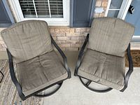 Front view of two aluminum swivel and rocking patio chairs with beige cushions showing condition and design.