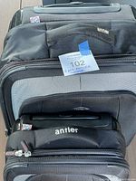 Two black Antler luggage pieces stacked showing fabric fronts and handles.