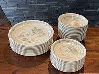 Stacked dishes showing side plates and bowls, with pastel pink and sage green Asian-themed pagoda design.