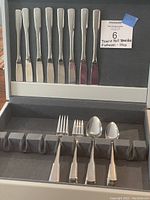 Full view of knives, forks, and spoons displayed inside the grey wooden box with Jasco branding.