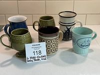 Overview of all six mugs in the lot showing variety of colors and styles