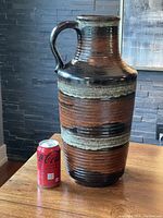 Full view of the large floor vase beside a soda can to illustrate size and detail of rust, taupe and brown glaze.
