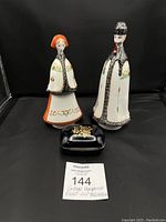 Photo showing the three porcelain items: the male and female figurines in traditional dress, and the cobalt blue trinket dish with a gold floral lid.