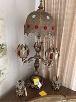 Full view of vintage brass chandelier lamp with two side lamps and two candle holders on table