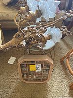 Top angle view showing the brass light sconces with rose-shaped frosted glass shades and the wooden display case with multiple miniature figurines inside.