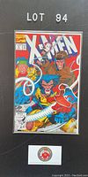 Photo of X-Men issue #4 comic book in a protective bag and board showing vibrant cover art with Wolverine and other characters, labeled Lot 94.