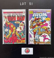 Photo showing two Iron Man comic books bagged and boarded. Left: The Invincible Iron Man #73 from 1975 with classic red and gold armor cover. Right: Iron Man Annual #11 from 1990, 64 pages, titled 'The Terminus Factor' featuring Iron Man fighting a beast.