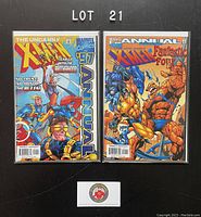 Photo showing two comic books from The Uncanny X-Men Annual series from 1997 and 1998, both bagged and boarded and labeled as Lot 21.