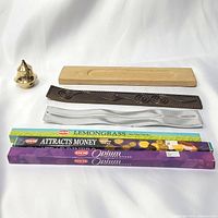 Three incense burners displayed with four boxed incense sticks, showing variety of materials and incense types.