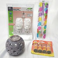 Lot overview showing soapstone oil burner, fly traps, head massager, Sylvania micro-mini CFL light bulbs