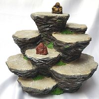 Multi-level stone style display stand with two Buddha statues placed on different levels, front view