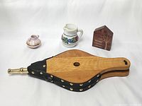 Top view of the fireplace bellows, two vases, and inspirational wooden plaque showing materials and decorative details