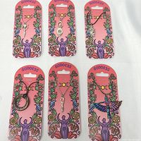 Front view showing all six goddess necklaces on pink backing cards with colorful mystical designs.
