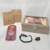 Overview of jewelry box, bracelets, keychain, stone bracelet, and tiger eye bear figurine