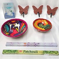Photo showing all items together including glass butterfly, 3 wooden butterfly wall hooks, 2 Mexican ceramic bowls, and 2 incense stick packs.