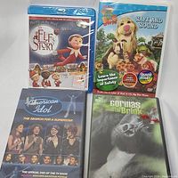 Four DVDs and Blu-ray discs from the lot shown together, sealed in plastic wrap.