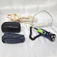 Philips electric shaver plugged into power bar with two carrying cases and second power bar visible