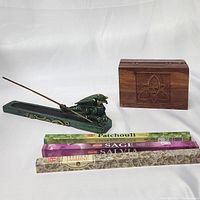 Green steampunk dragon incense burner holding incense stick, wooden triquetra box, and three incense packs