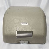 Closed view of vintage Adler Junior-E typewriter in metal carrying case showing aged and worn exterior.