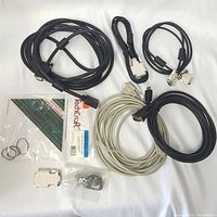 Overview photo showing a collection of assorted vintage computer cables in black and gray colors. Accessories include plastic mounting brackets and small metal screw rings in packaging.