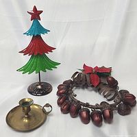 Full lot showing colourful metal Christmas tree, copper acorn nut wreath, and brass candle holder.