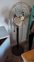 Full view of the vintage Torcan metal floor fan standing on a metal base, showing overall height and structure.