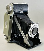 Front left perspective view of the Kodak Tourist II foldout camera showing extended bellows, lens, and metal body.