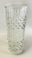 Front view of clear textured glass vase showing raised candlewick bead-like pattern and cylindrical shape.
