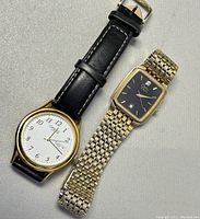 Two men's Caravelle by Bulova wristwatches: one with white dial and black leather strap, the other with black dial and gold-tone metal bracelet.