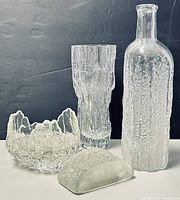 All four glass pieces displayed together on black background.