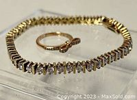 Close shot showing both tennis bracelet and rose-gold Pandora ring with bow-tie design and CZ stones.