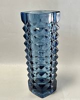 Side angle view of blue geometric Czech crystal vase showcasing faceted diamond pattern and hexagonal shape.