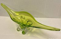 Side angle showing freeform shape, green-to-clear Sommerso glass transition, and base feet