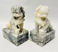 Pair of Foo Dog stone carvings front and angled view showing marbled stone pattern and carved details