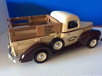 Side view of 1940 Ford pickup truck model showing cream and dark brown paint, wooden bed with 'Orchard Supply Hardware' branding