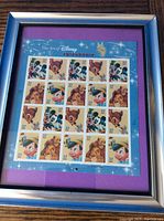 Framed sheet of 20 Disney 37 cent unused postage stamps titled 'The Art of Disney Friendship' with purple mat and silver frame.