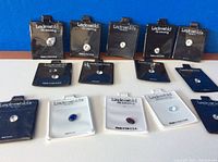 Several Lindenwold branded cards each holding a single clear round brilliant-cut stone and three white cards with colored oval stones (blue, red, light blue).