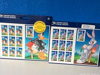 Photo showing both unopened sheets of 33 cent postage stamps featuring Bugs Bunny and Daffy Duck with United States Postal Service branding.