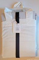 Packaged folded cotton duvet covers with handle and tag showing branding and fabric content.