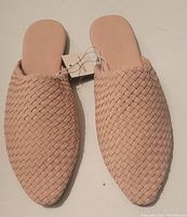 Top down view of new women's woven flats in light blush pink color with attached tag visible.