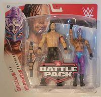 Front view of WWE Battle Pack with Shinsuke Nakamura and Rey Mysterio action figures and belt inside packaging.