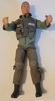 Front view of the 12 inch GI Joe Ace figure showing face, vest with U.S. Air Force patch, green and brown flight suit, and black boots.