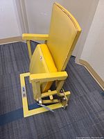 Side view showing backrest, padded seat, armrest and folding mechanism