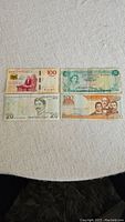 Four banknotes displayed on a flat surface showing Mexican, Bahamian, Turkish, and Dominican currency.