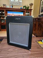 Front view showing the large metal mesh speaker grille and Aria logo.