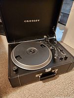 Front view of Crosley Keepsake Deluxe turntable inside open case with platter and tonearm visible