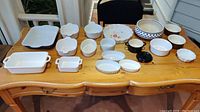 Overview photo showing all ceramic kitchen bakeware and ramekin dishes arranged on wooden table