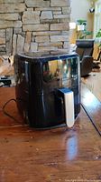 Side view of the black Salton air fryer showing its glossy finish and pull-out handle.