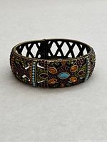 Front view showing colorful crystal Art Deco pattern on the bracelet watch with turquoise and amber centerpiece details.