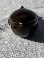 Top view of the small hand-carved teak whale showing the detailed fins and smooth finish